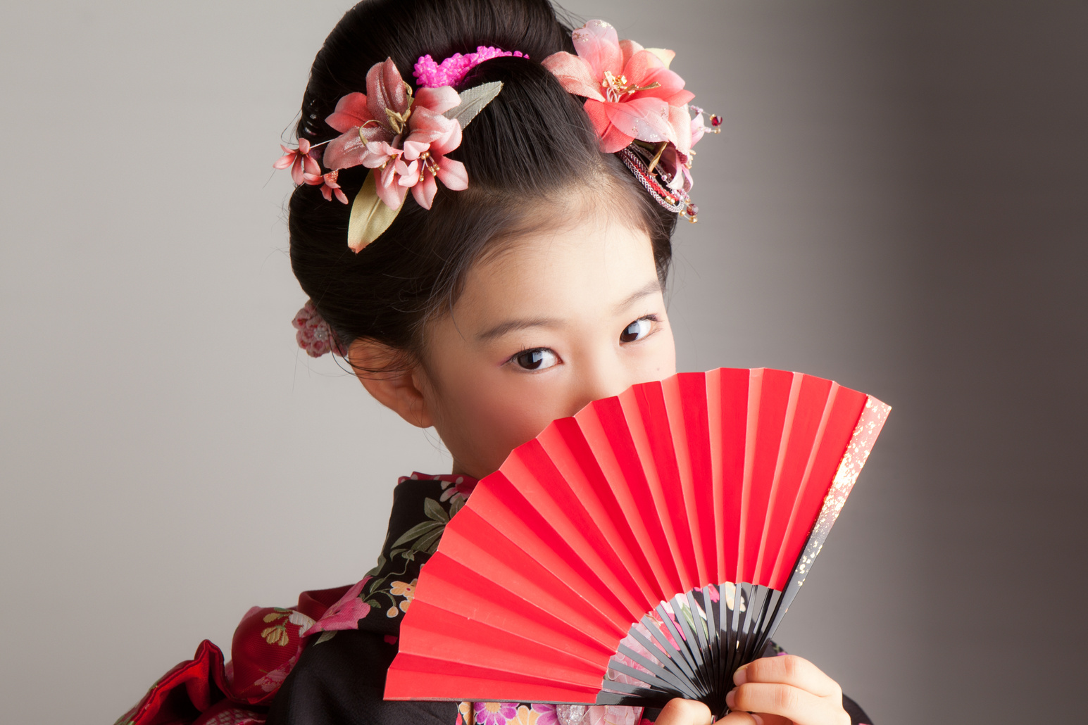 Young Japanese girl celebrating Shichi-Go-San with a red fan